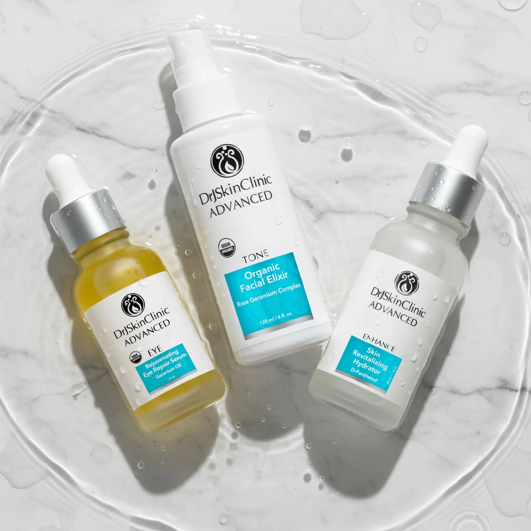 Three Dr. Skin Clinic Advanced products—Rejuvenating Eye Repair Serum, Organic Facial Elixir toner, and Skin Revitalizing Hydrator—arranged as The Radiance Renewal Trio skincare set.